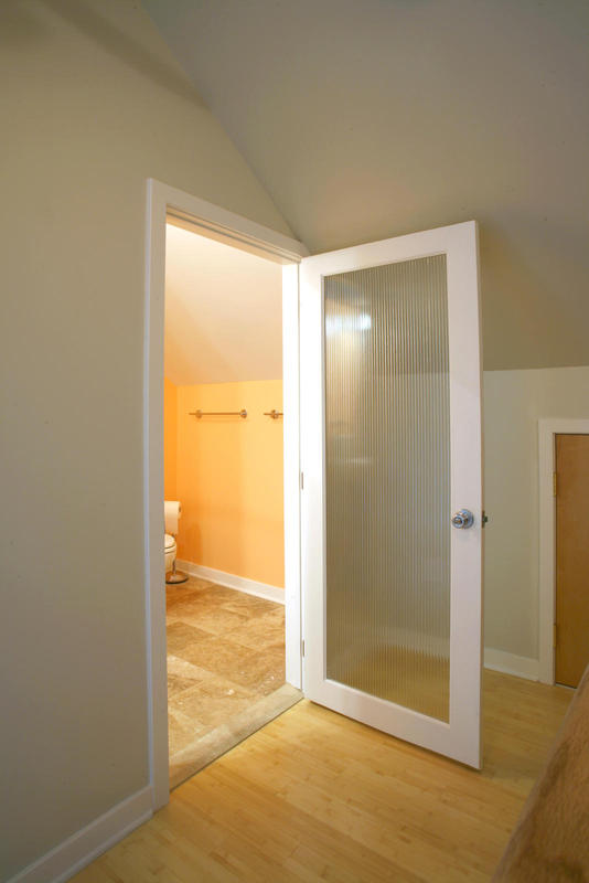 Obscured glass door allows for more light into bathroom.